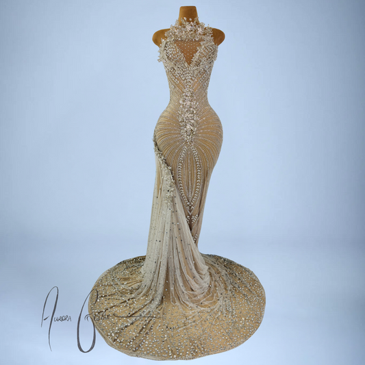 Elaborately beaded and embroidered evening gown on a mannequin against a light blue background.