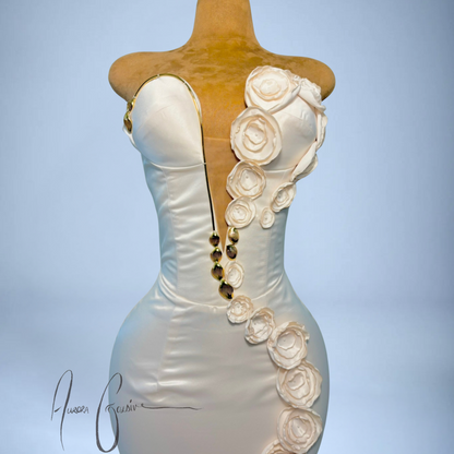 White wedding dress with floral embellishments on a mannequin against a light blue background
