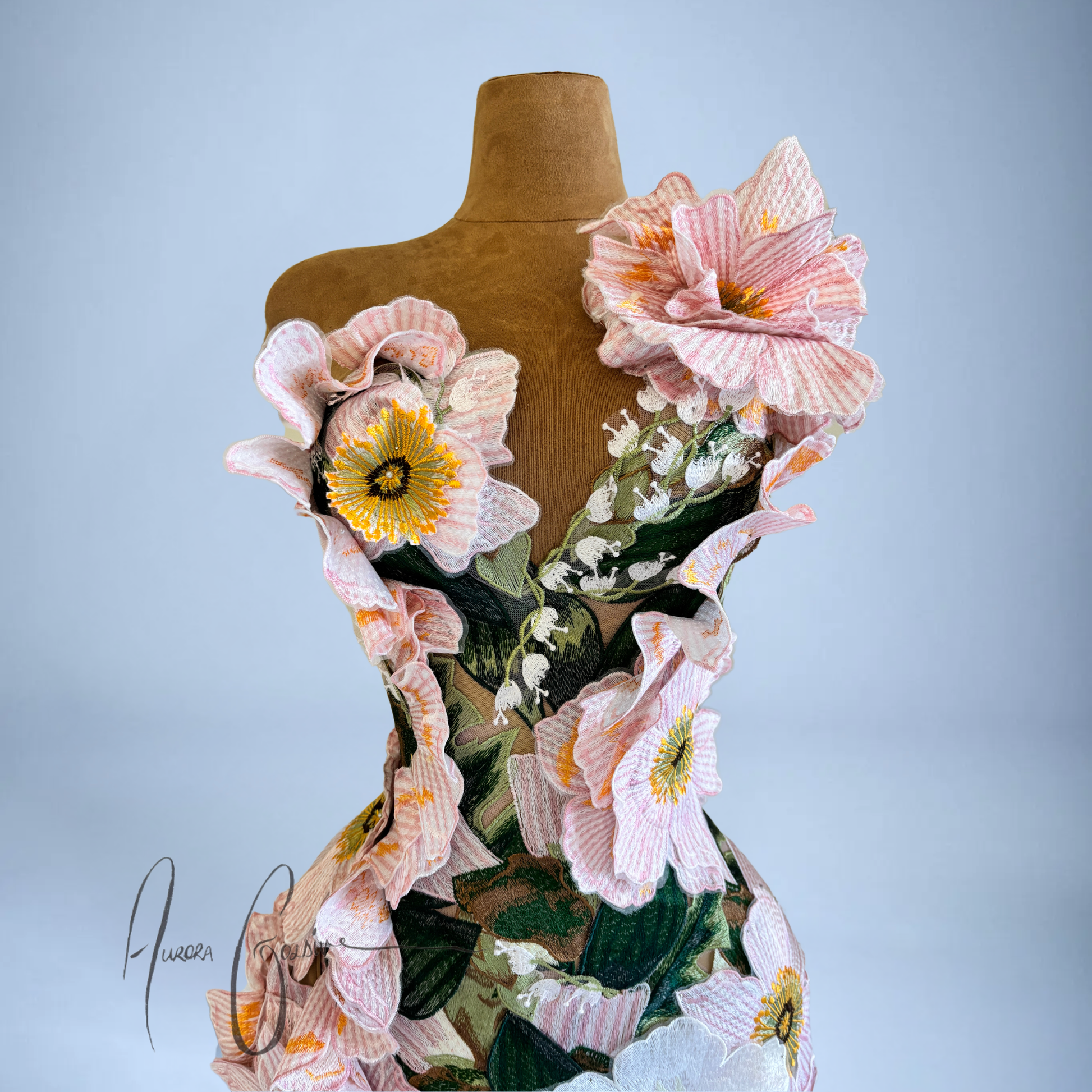 Amelia Gown pink floral mermaid wedding dress on a mannequin against a light blue background