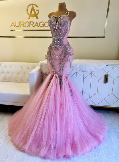Pink evening gown with beaded details on a mannequin against a branded background